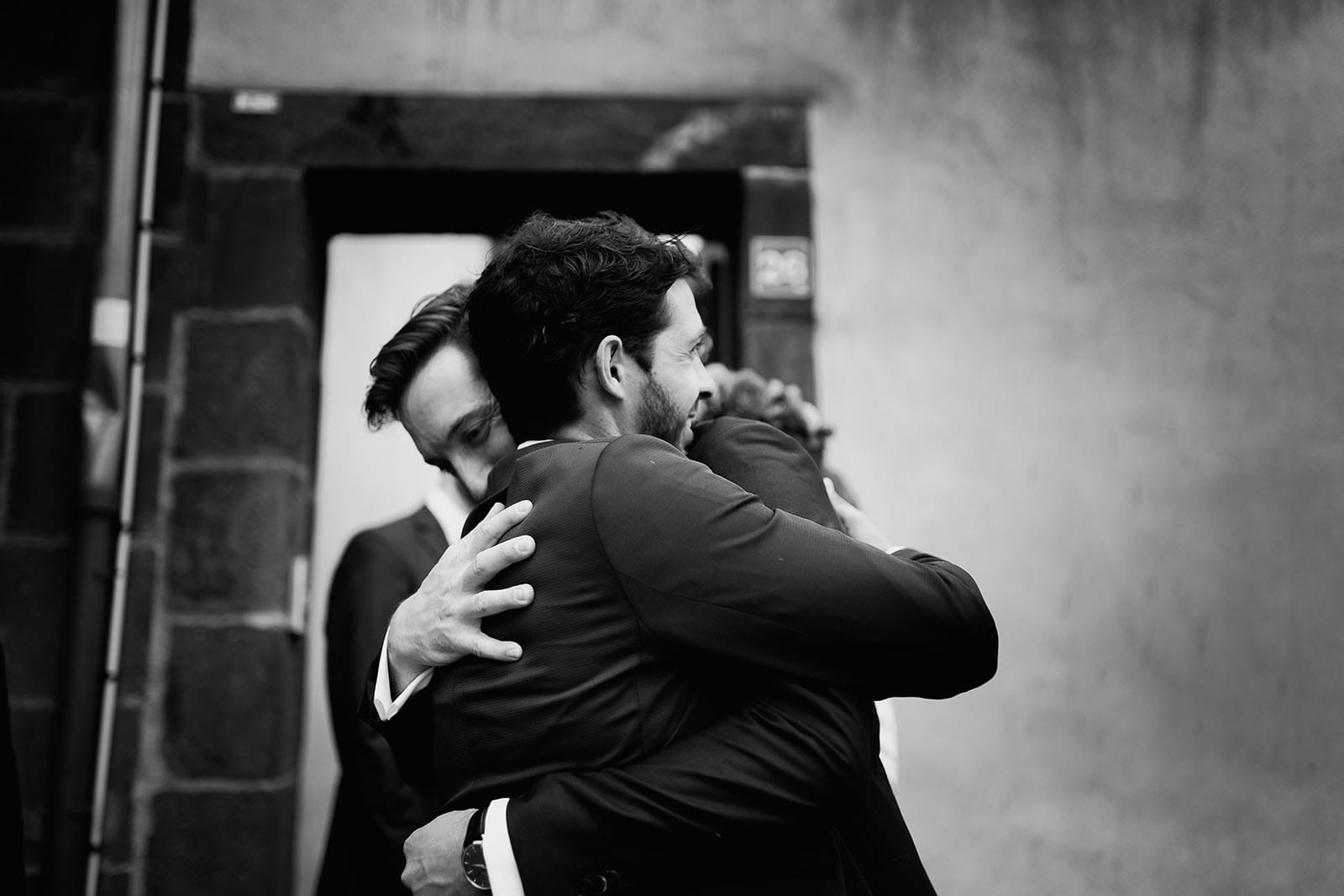 Photographe de mariage à Clermont Ferrand Le marié prend dans ses bras un témoin