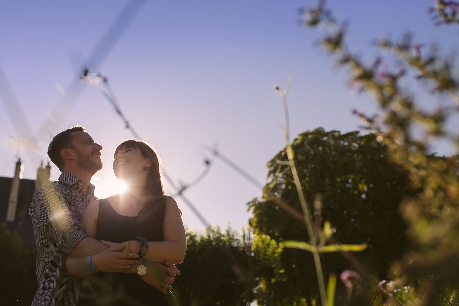 Photographe de mariage château le sallay nevers Love session ou séance d'engagement à Paris d'une jeune couple qui rient ensemble. Photo à contre jour avec une belle lumière et le soleil