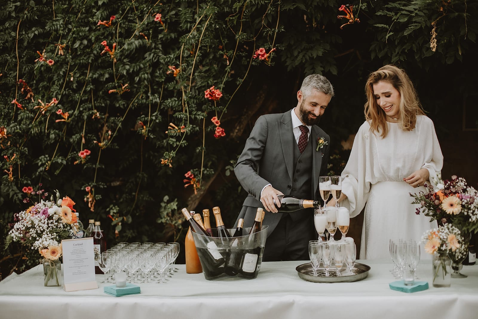Mariés servant le champagne lors du cocktail de mariage au Manoir de Tourville – reportage photo naturel et élégant à Lyon.