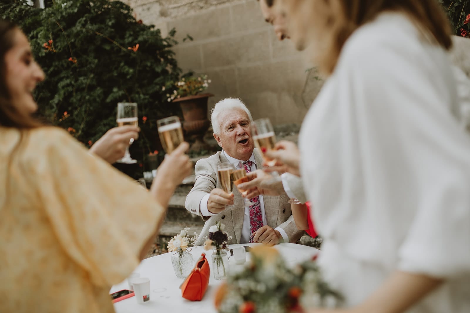 Invité levant son verre de champagne lors du cocktail de mariage au Manoir de Tourville – reportage photo spontané et chaleureux.