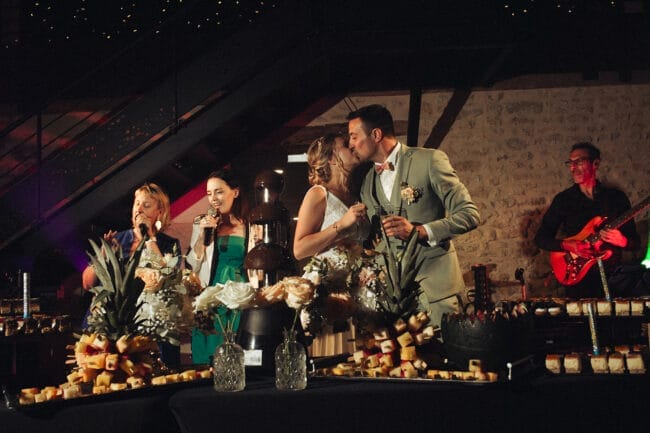 Mariés s’embrassant près de la fontaine à chocolat lors de la soirée au Domaine de la Pierre