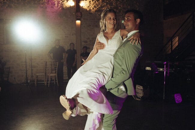 Marié portant sa femme sur la piste de danse lors de la soirée au Domaine de la Pierre