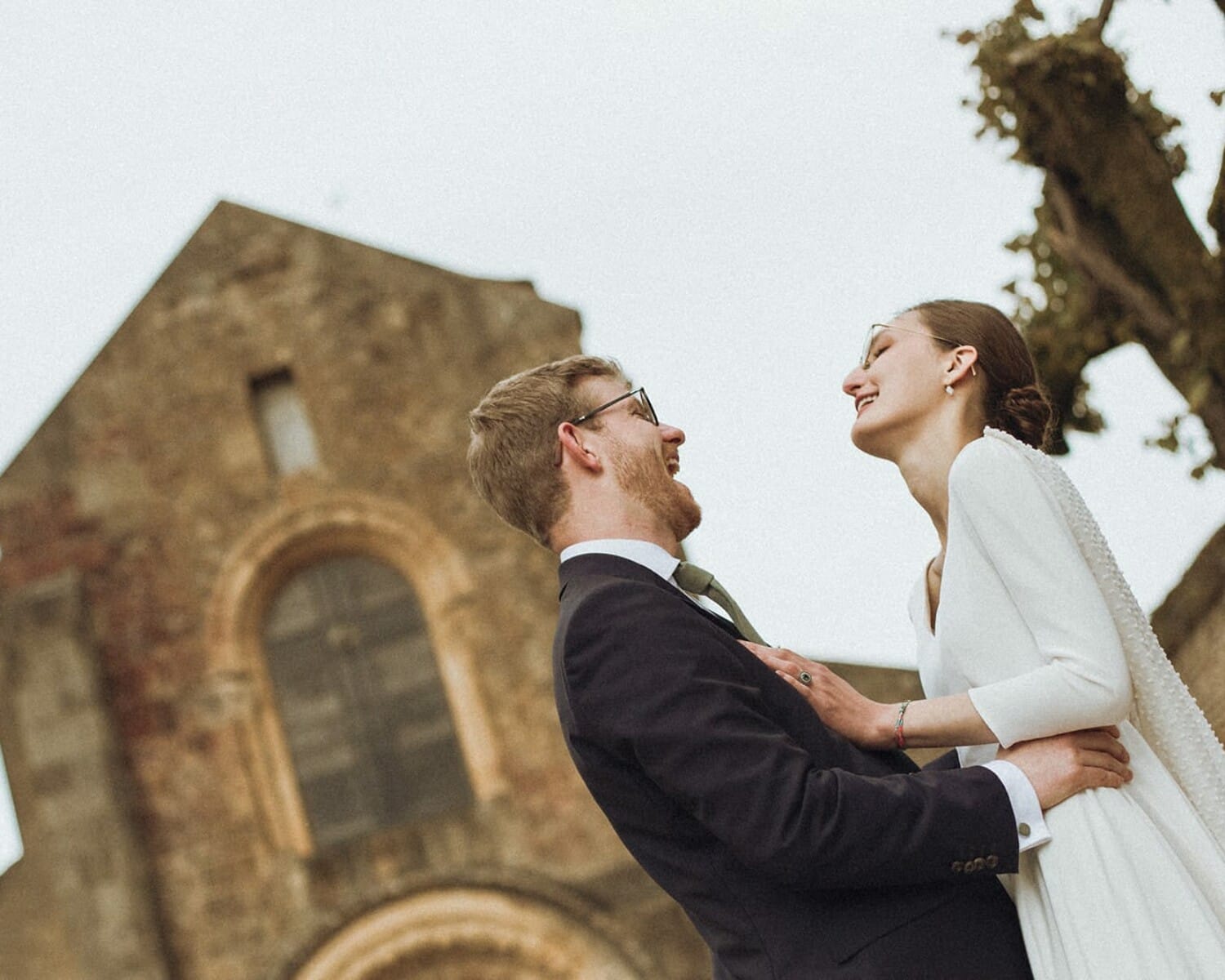 Mariés souriants devant l’église romane d’Anzy-le-Duc – mariage en Bourgogne