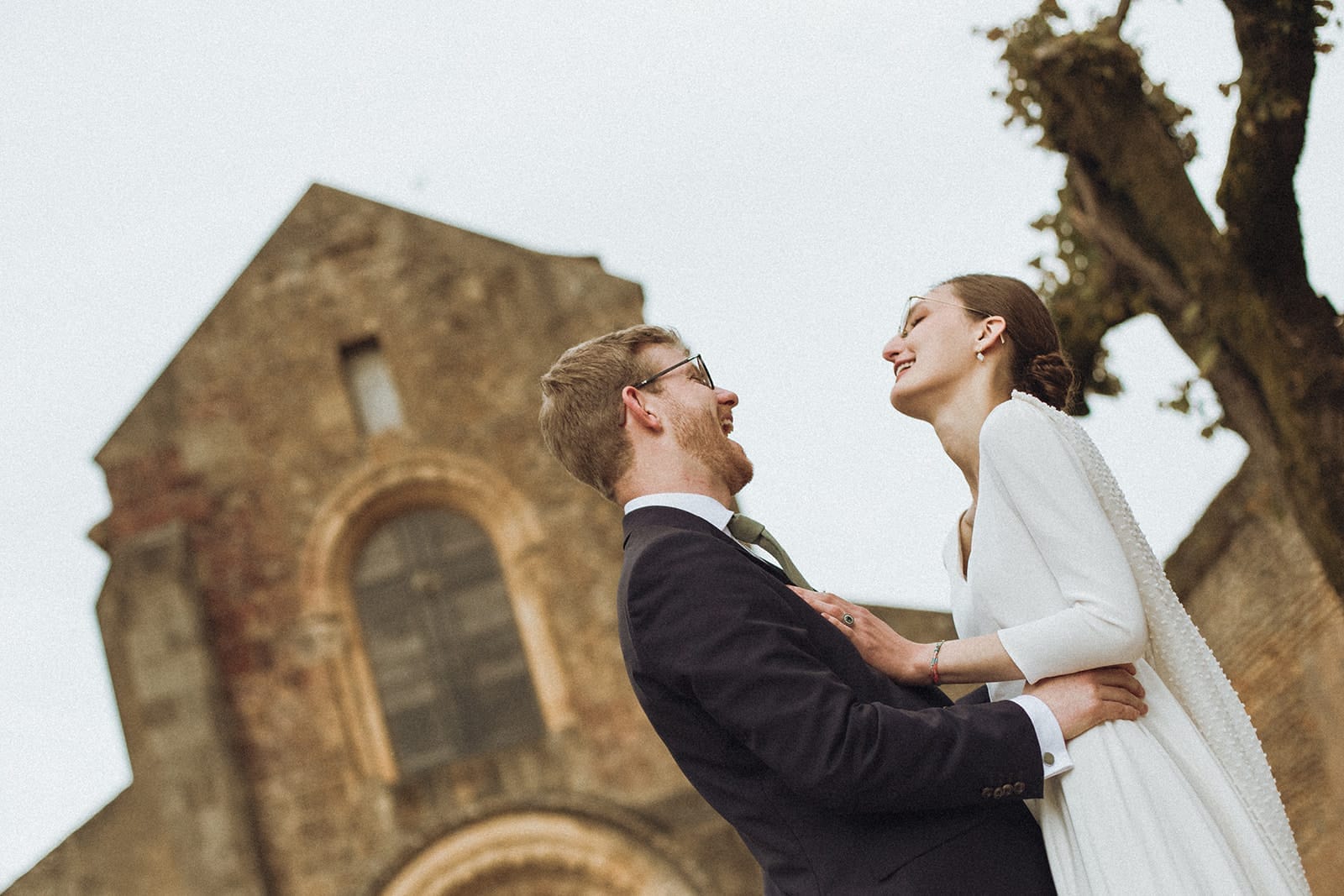 Mariés souriants devant l’église romane d’Anzy-le-Duc – mariage en Bourgogne
