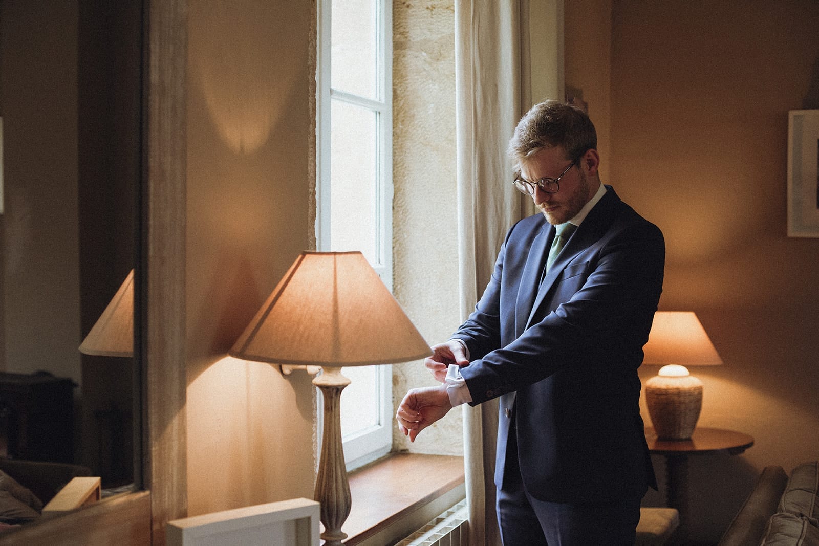 Marié ajustant sa manche de costume lors des préparatifs – mariage à Anzy-le-Duc en Bourgogne