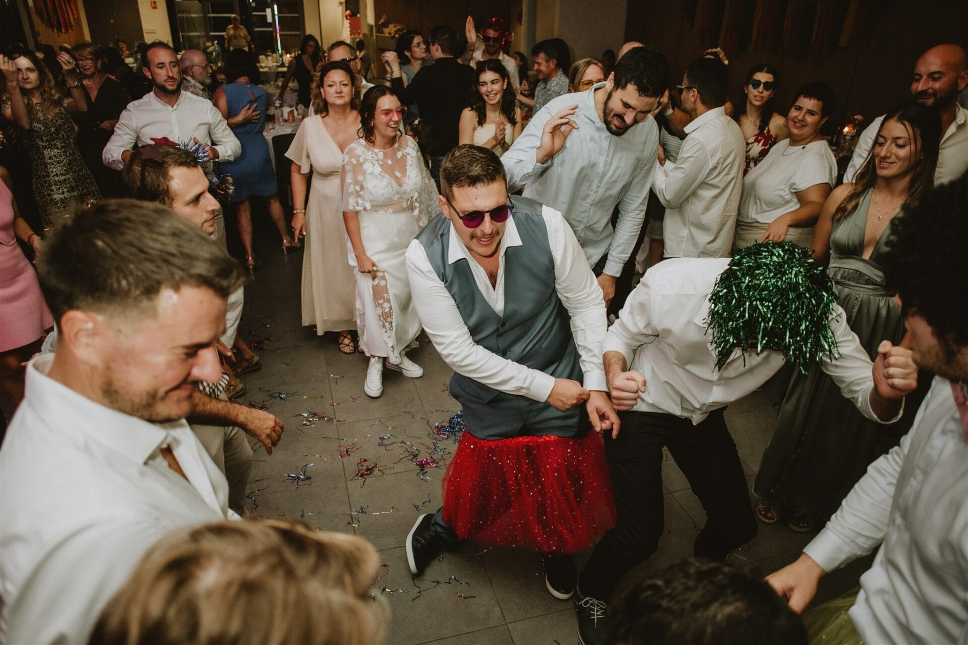 Invités en cercle entraînant un danseur au centre pendant une soirée de mariage animée