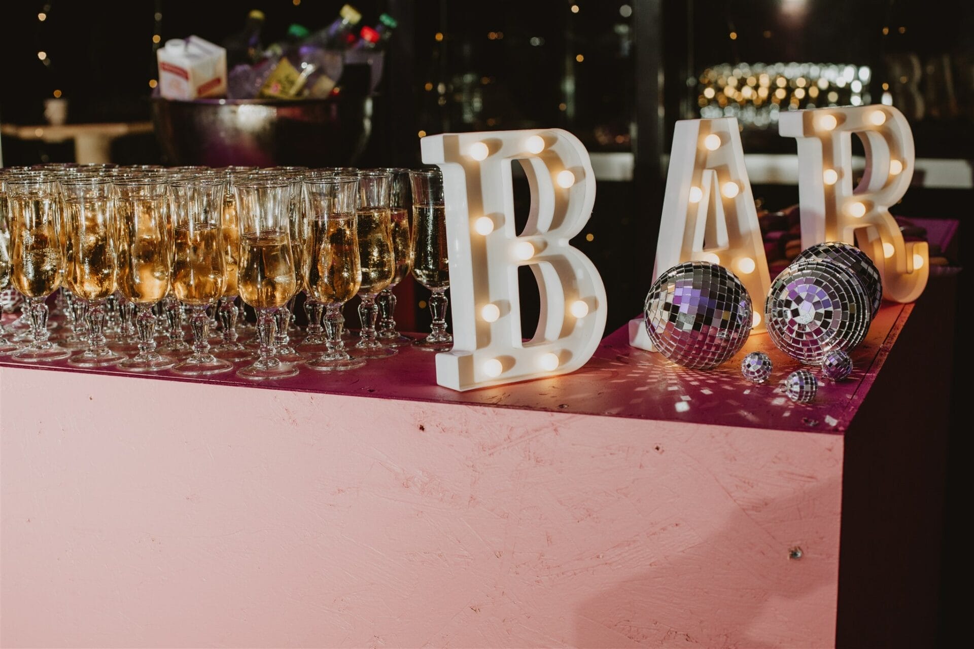Bar de soirée de mariage avec lettres lumineuses et flûtes de champagne prêtes pour la fête